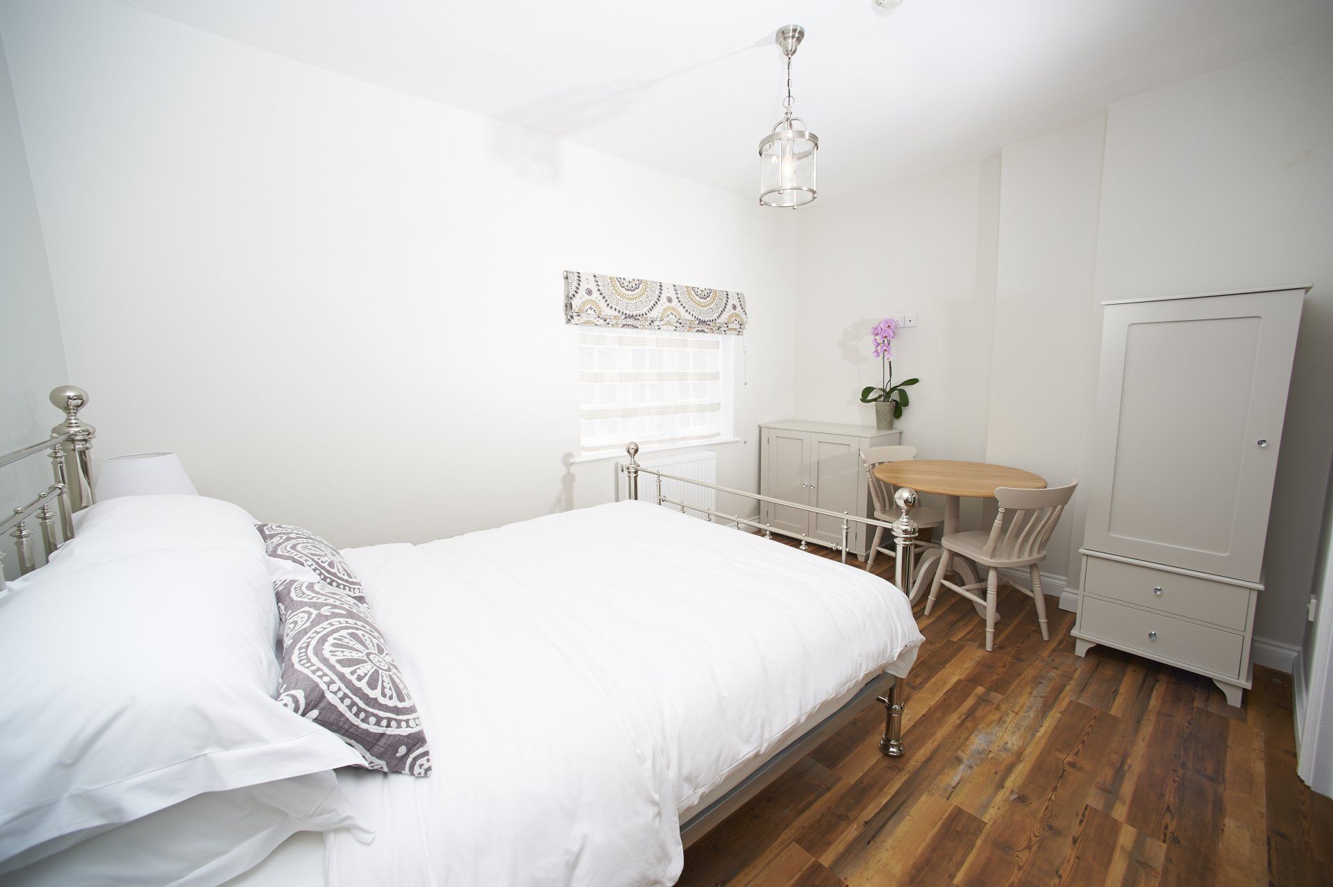 A bedroom with a bed , desk and chairs