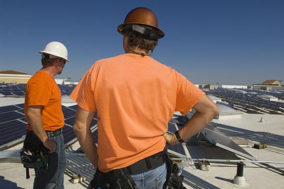 a couple of men standing on top of a roof