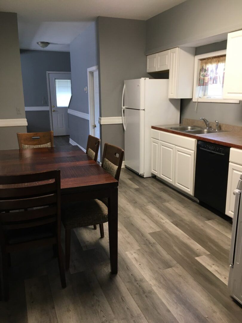 A kitchen with a table and chairs and a refrigerator