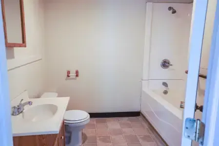 A bathroom with a toilet , sink , and bathtub.