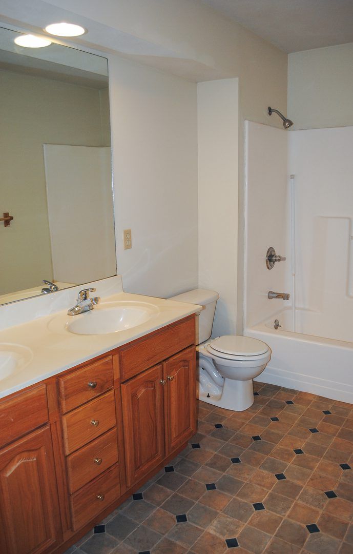 A bathroom with two sinks a toilet and a bathtub