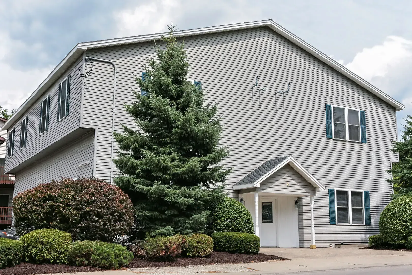 A large house with a lot of windows and a tree in front of it