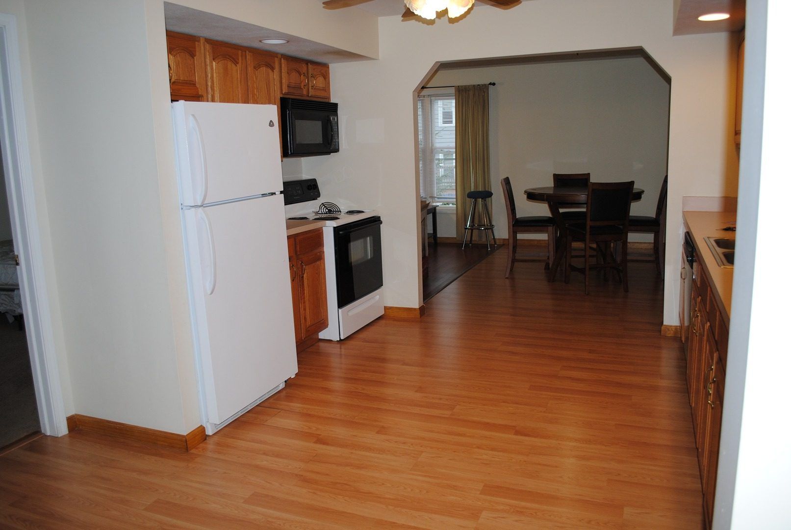 A kitchen with hardwood floors and a white refrigerator