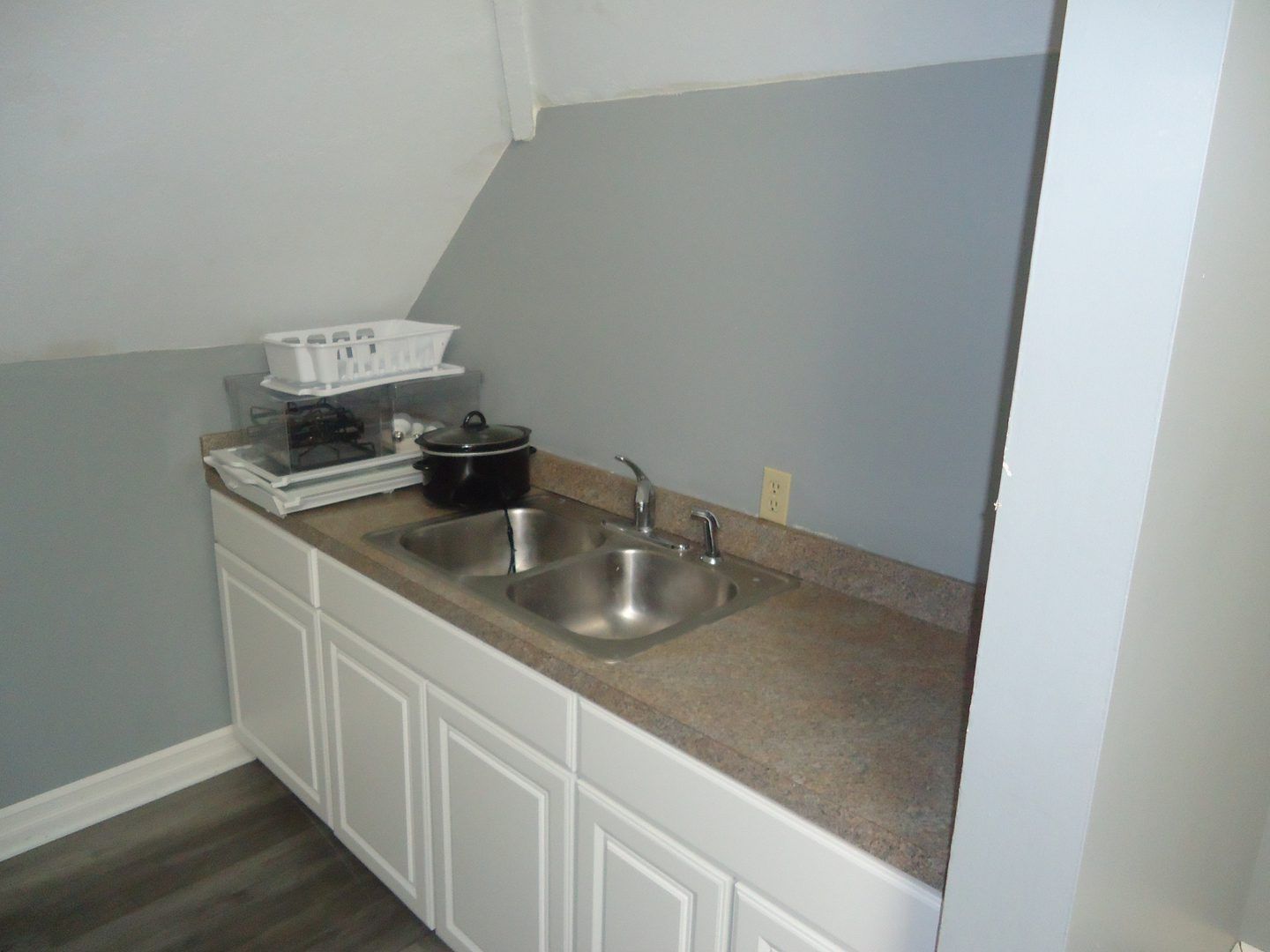 A kitchen with a sink and white cabinets