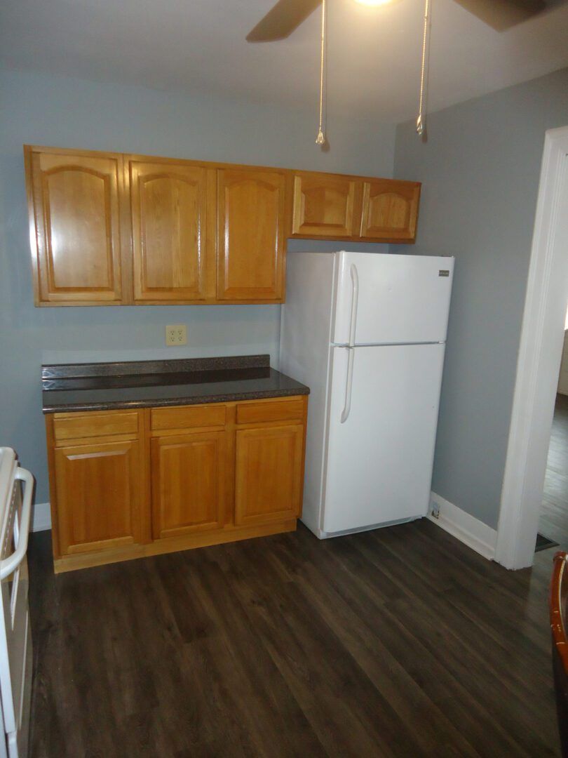 A kitchen with wooden cabinets and a white refrigerator