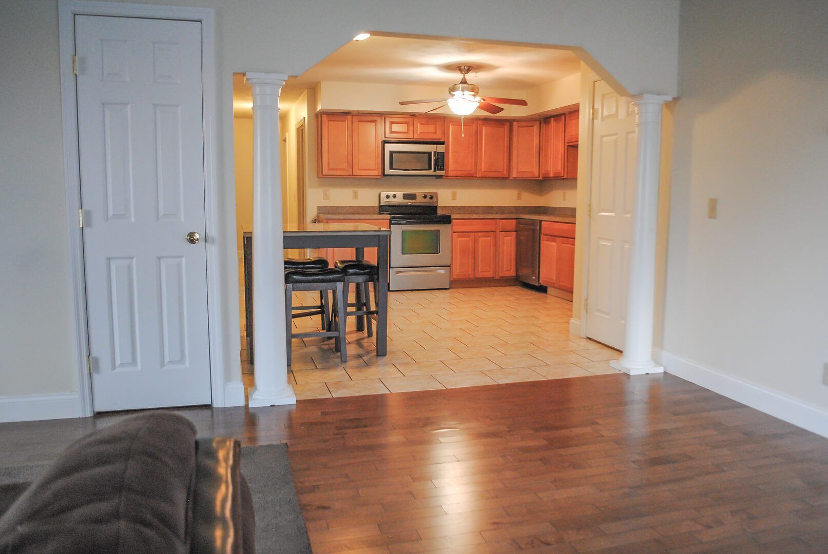 A living room with a couch and a kitchen in the background