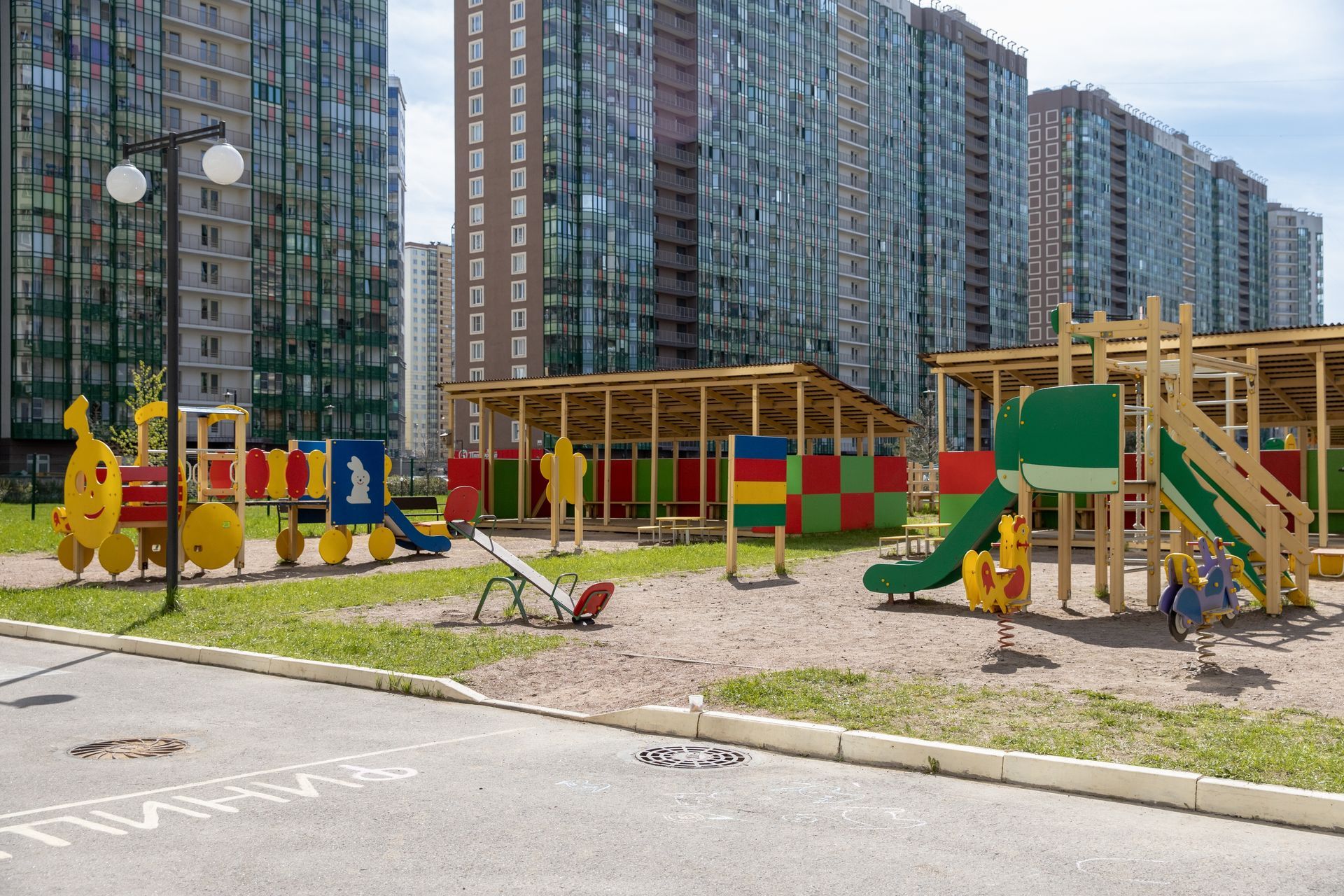 A playground in front a lot of buildings in the background.