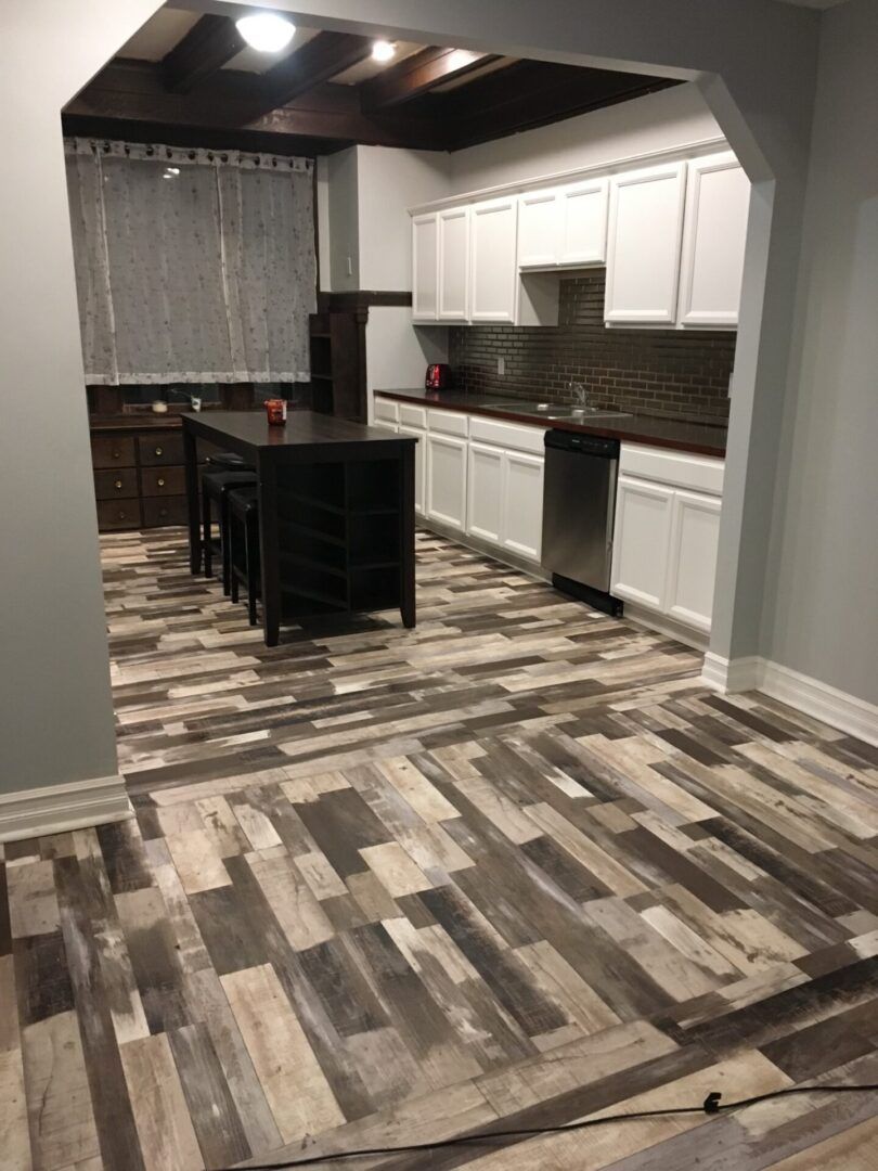 A kitchen with a wooden floor and white cabinets