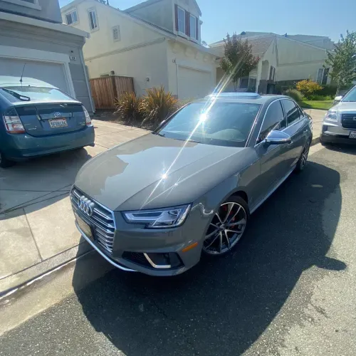 a gray car is parked on the side of the road