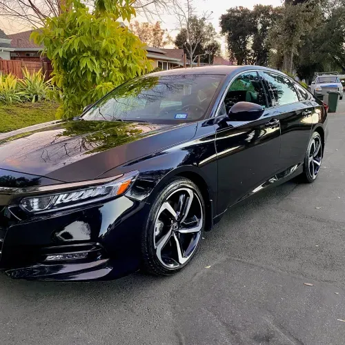a black car is parked on the side of the road .