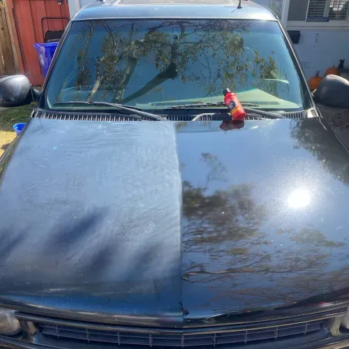 a black car with a bottle of water on the hood .