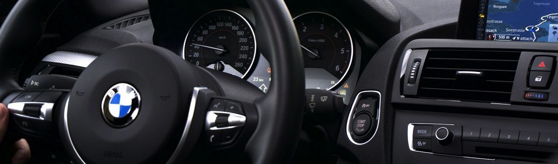 A close up of a bmw steering wheel and dashboard
