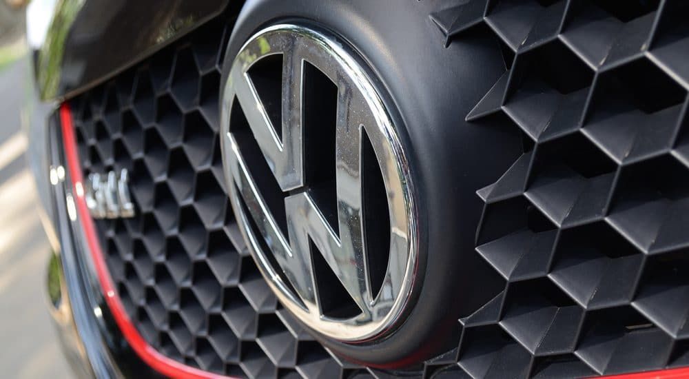 A close up of a volkswagen logo on the front of a ca