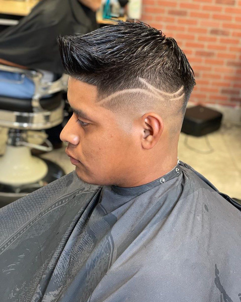 A man is getting his hair cut at a barber shop.