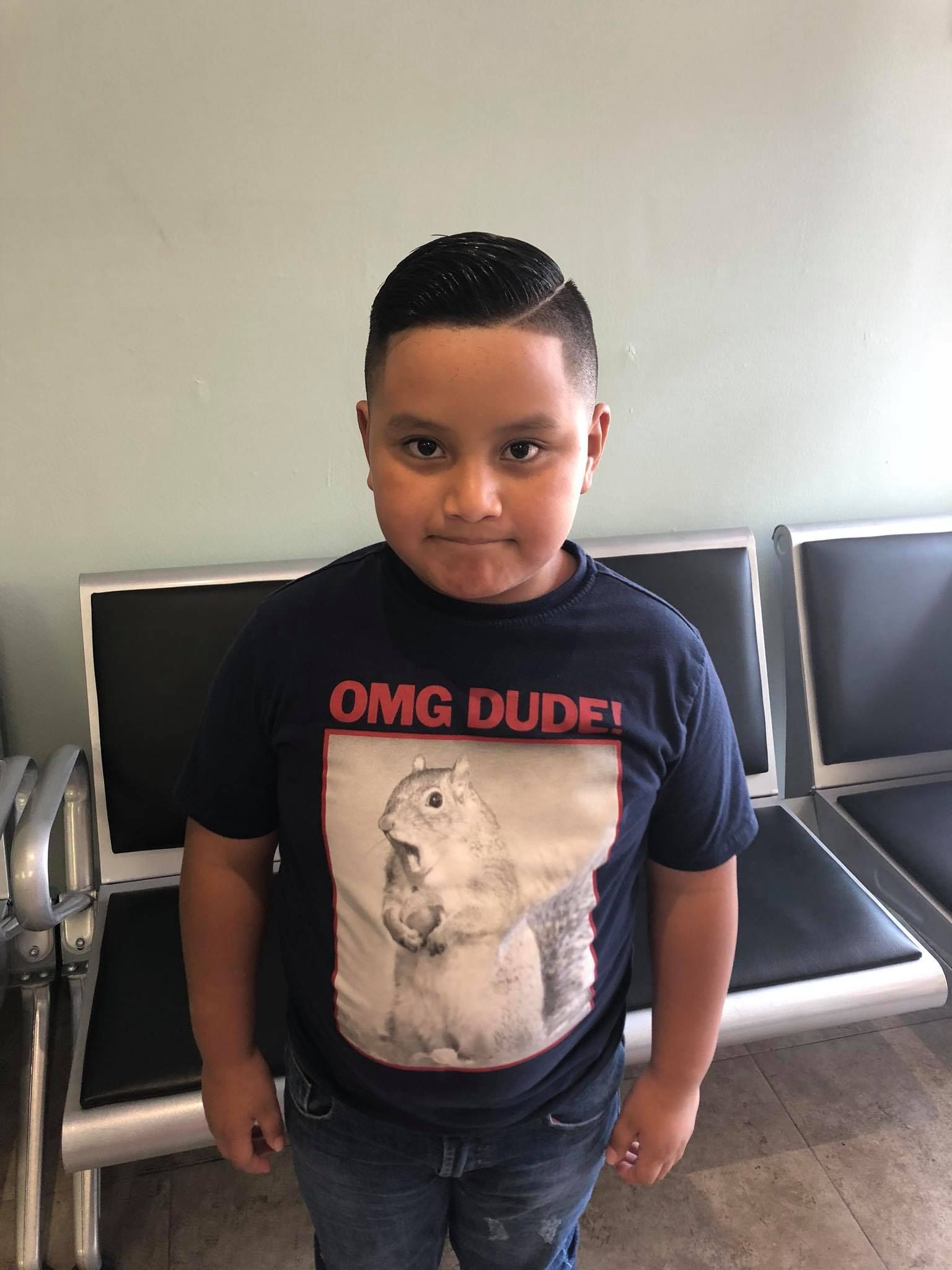 A young boy is wearing a t-shirt with a picture of a squirrel on it.