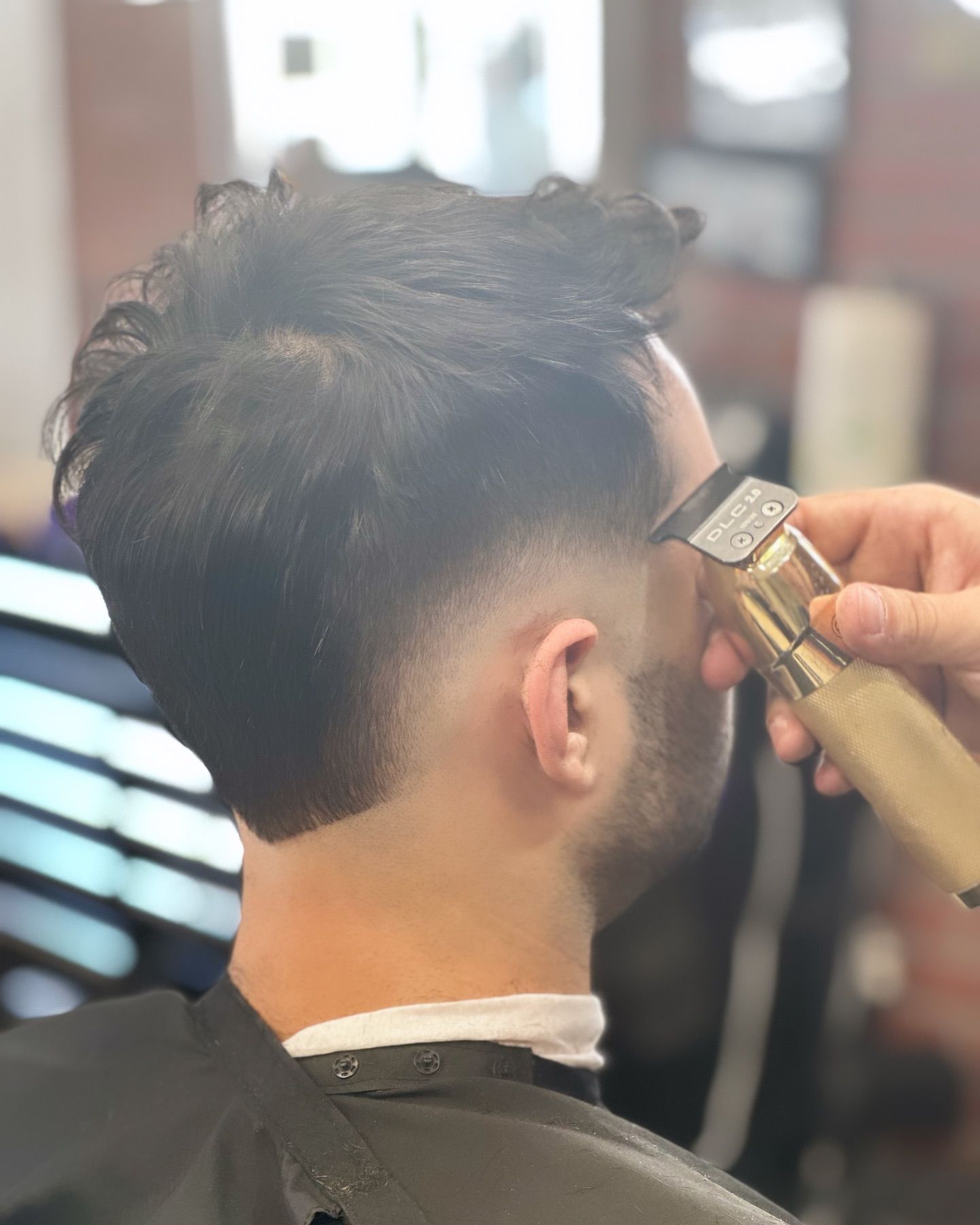 A man is getting his hair cut by a barber.