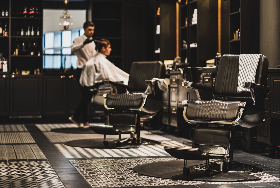 A man is getting his hair cut in a barber shop.