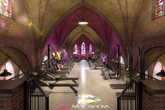 Een sportschool met veel apparatuur en een neonbord met de tekst 'kracht'.