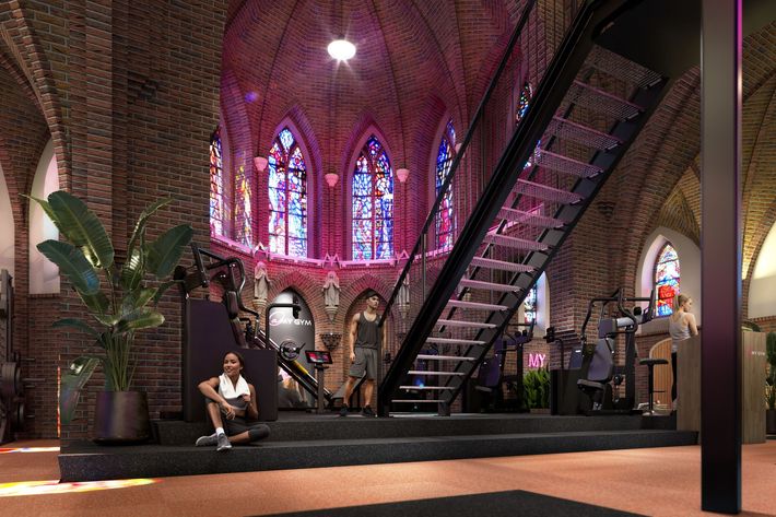 Een sportschool met veel apparatuur en een houten vloer.