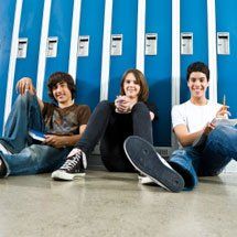children sitting in school hallway in front of lockers