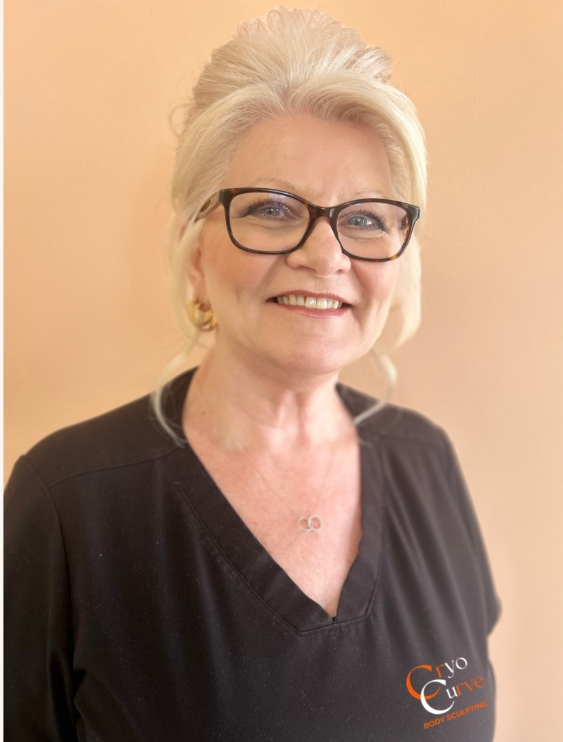 Woman with glasses smiling, wearing a black shirt, standing in front of an orange background.