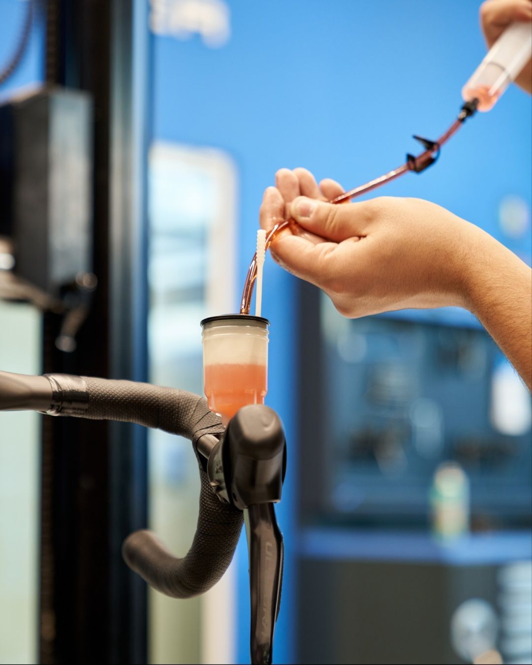 Una persona spurga l'impianto frenante idraulico di una bicicletta iniettando del liquido in un serbatoio fissato al manubrio.