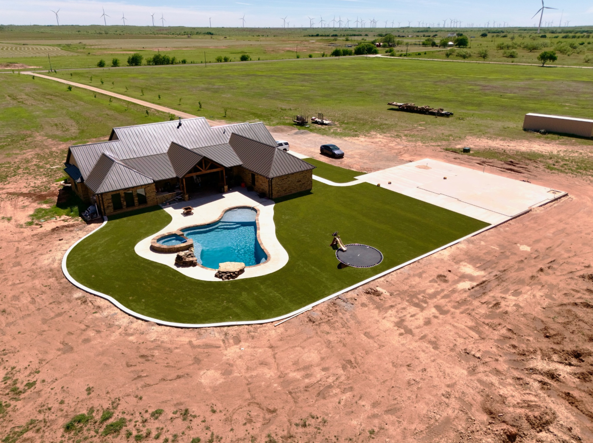 House with pool and manicured lawn in rural landscape.