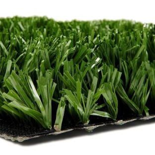 A close up of a piece of artificial grass on a white background.