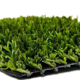 A close up of a piece of artificial grass on a white background.