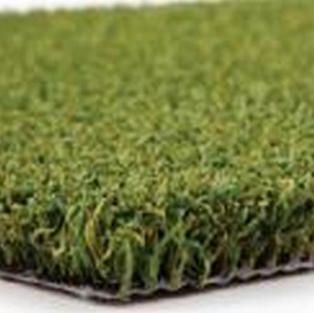 A close up of a piece of artificial grass on a white surface.