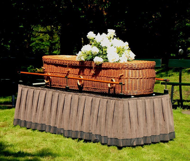 Eco-friendly green burial casket with white flowers on top