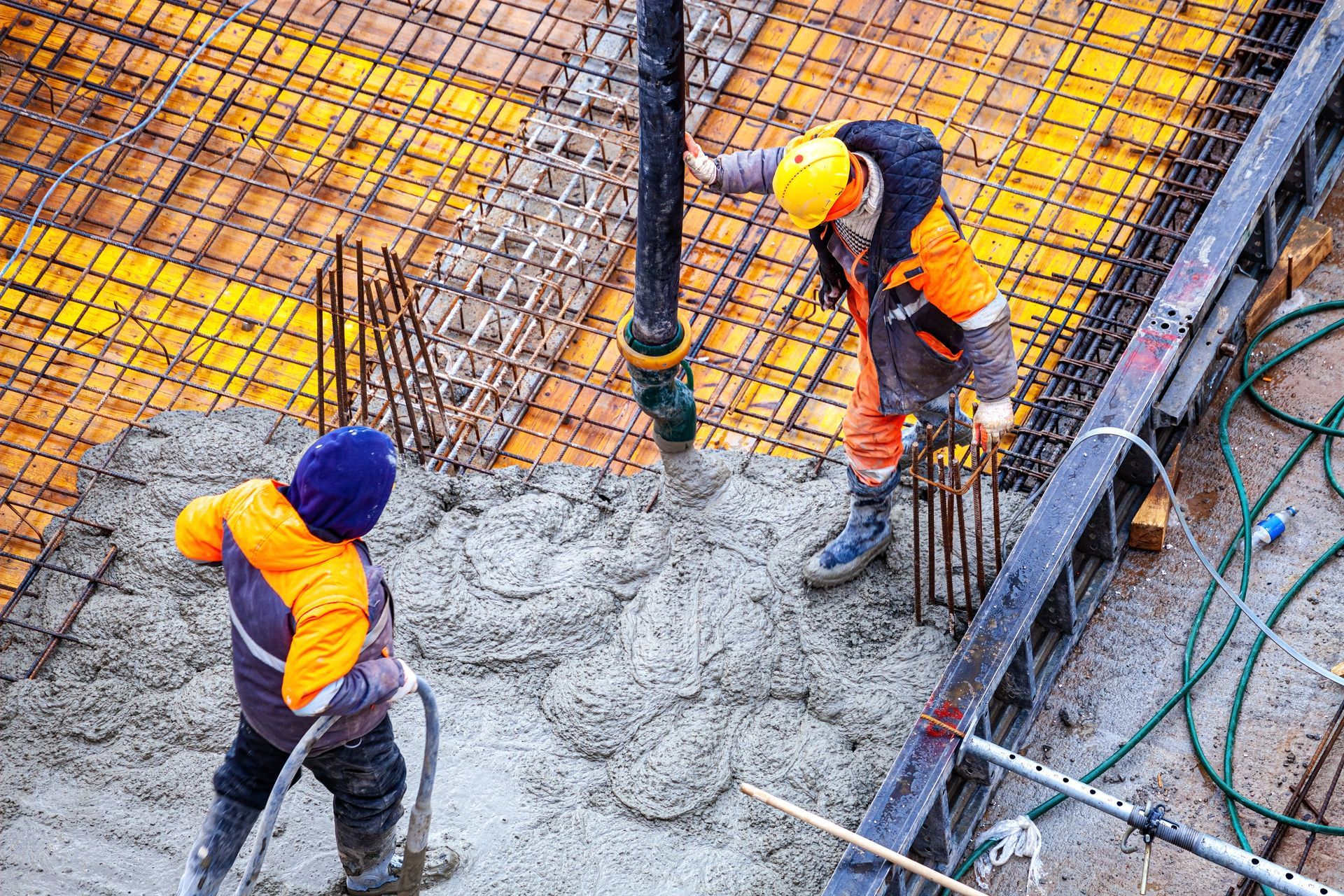Construction workers pouring concrete on a building site.