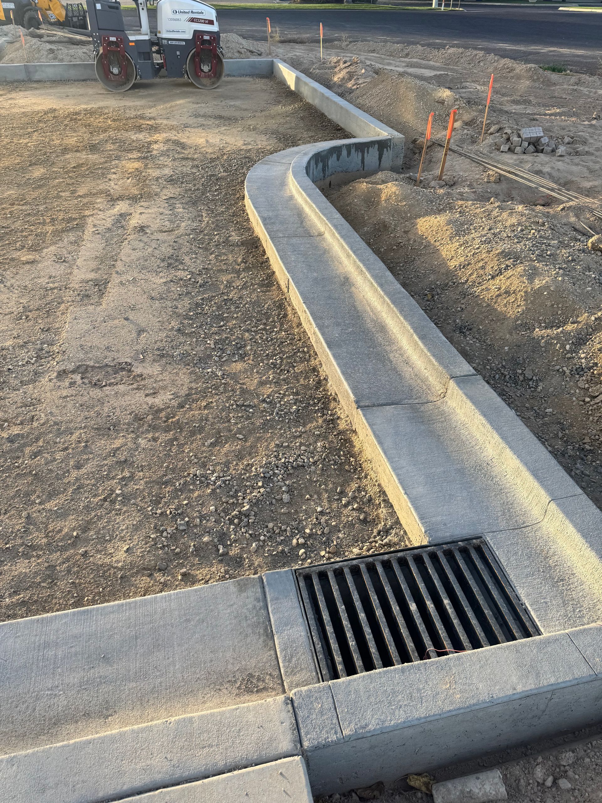 Concrete drainage channel with a grate in a construction site.