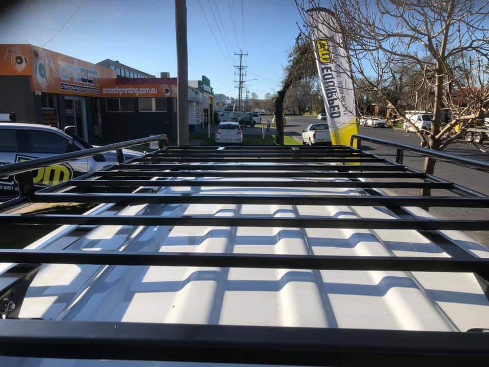 Black Roof Rack on a White Vehicle, With Buildings and a Street in the Background — TJM Albury Pty Ltd in South Albury, NSW