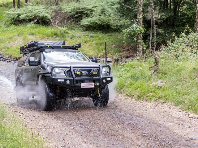 A SUV is Driving Down a Dirt Road in the Woods — TJM Albury Pty Ltd in South Albury, NSW