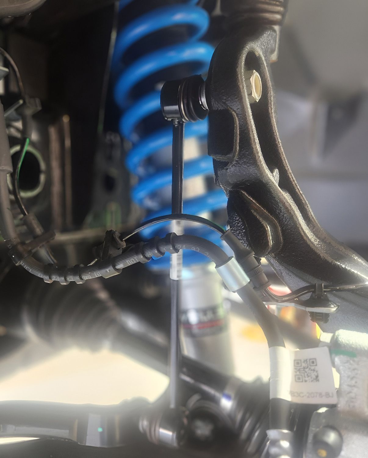 Close-Up View Of A Car's Suspension System With A Blue Coil Spring — TJM Albury Pty Ltd in South Albury, NSW