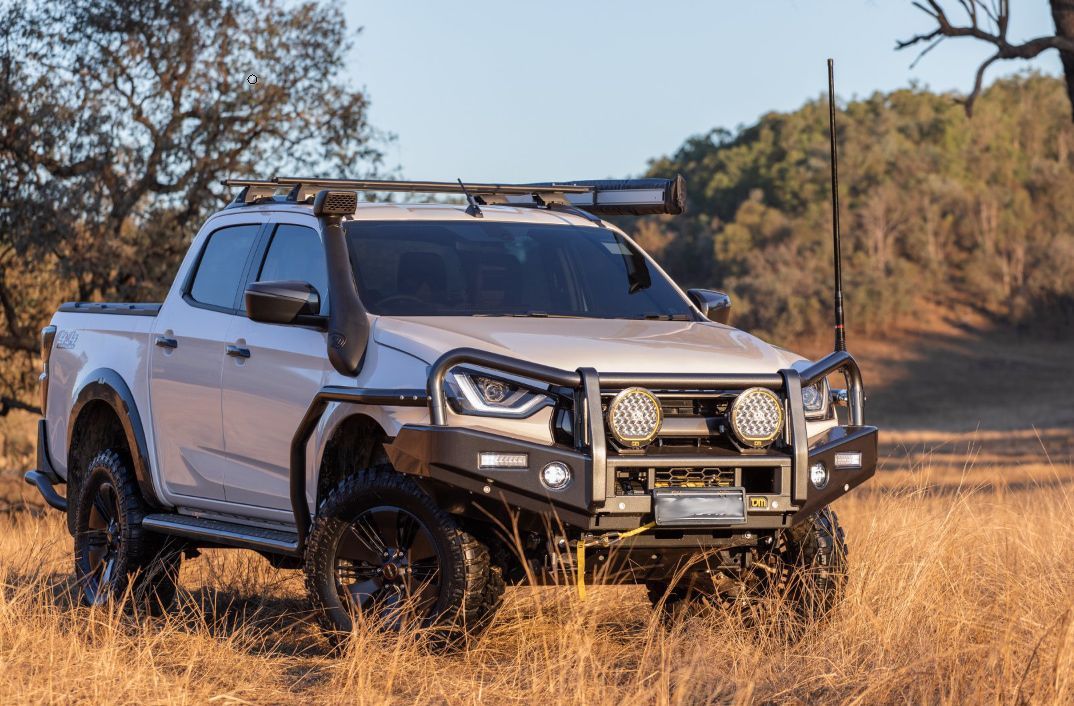 White off-road truck with black accessories in a grassy field. — TJM Albury Pty Ltd in South Albury, NSW