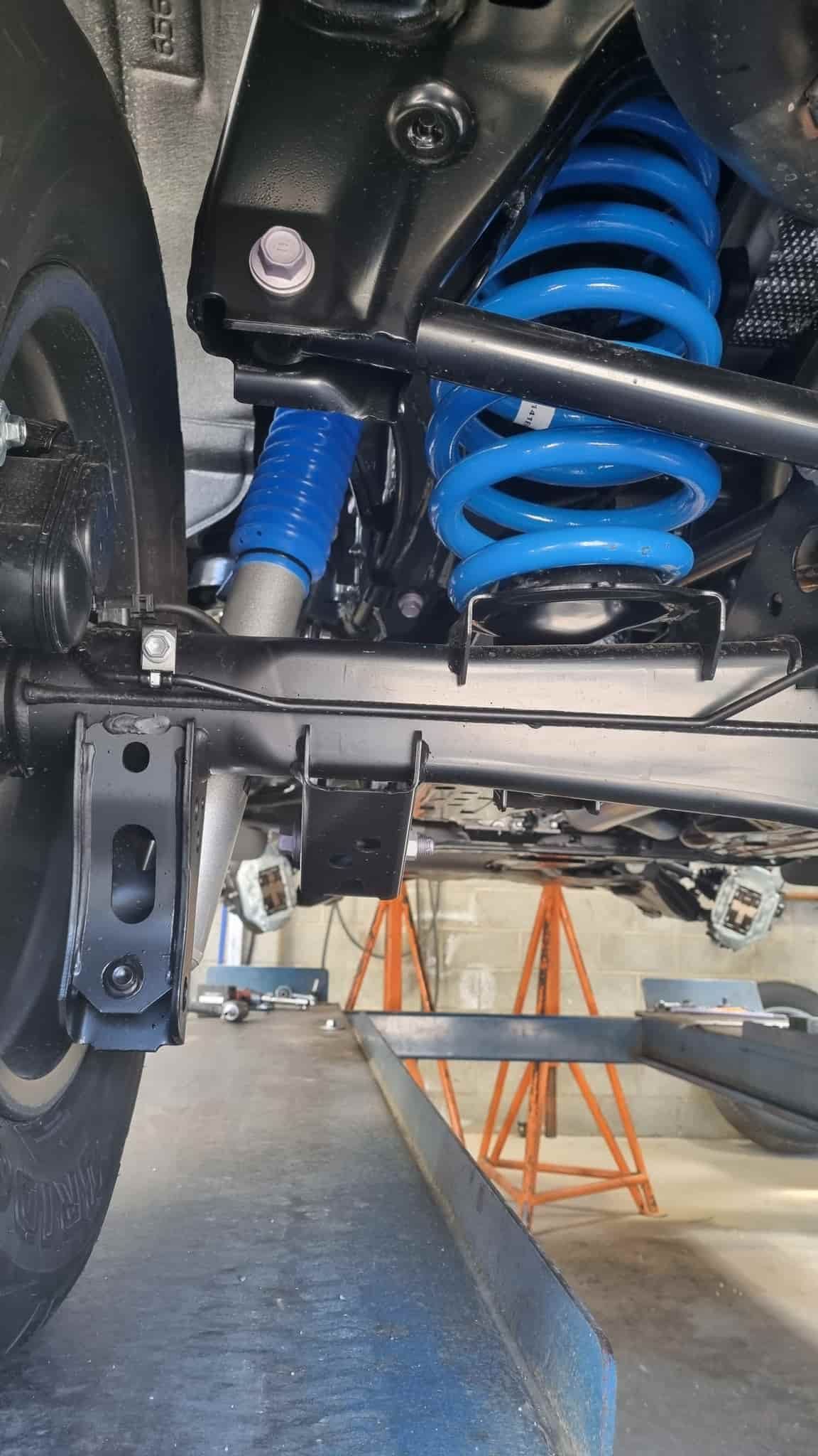 Blue Coil Spring Suspension on a Vehicle's Undercarriage in a Garage — TJM Albury Pty Ltd in South Albury, NSW