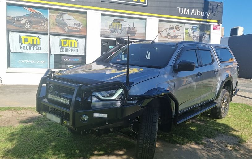Silver truck with black accessories parked in front of a store with display windows. — TJM Albury Pty Ltd in South Albury, NSW