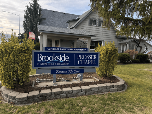 Building exterior with burgundy awning, windows, and sign that says 