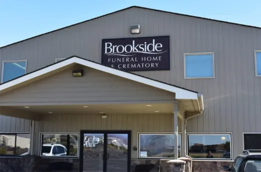 Brookside Funeral Home & Crematory, exterior view, beige building with sign, windows, and entrance.
