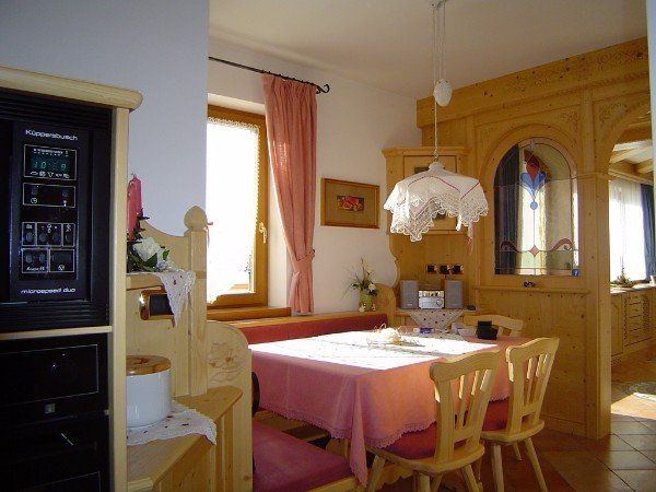 angolo cucina con tavolo e sedie in legno rustico