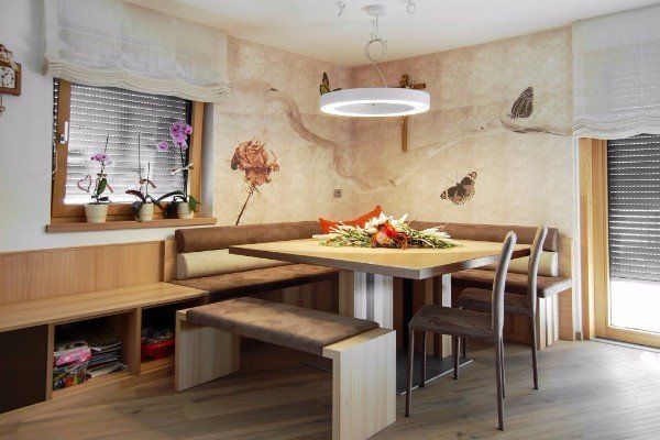 tavolo con sedie e sedute a parete