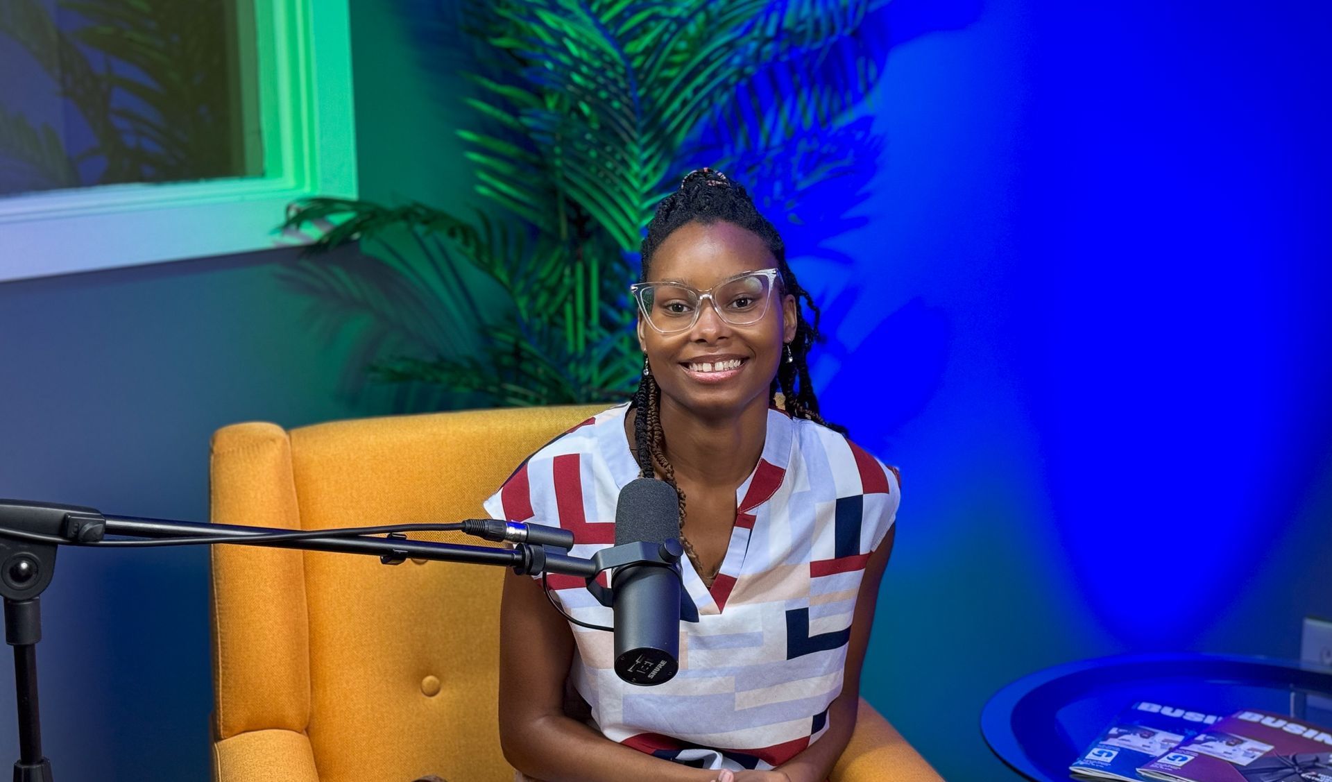 A woman is sitting in a chair in front of a microphone.