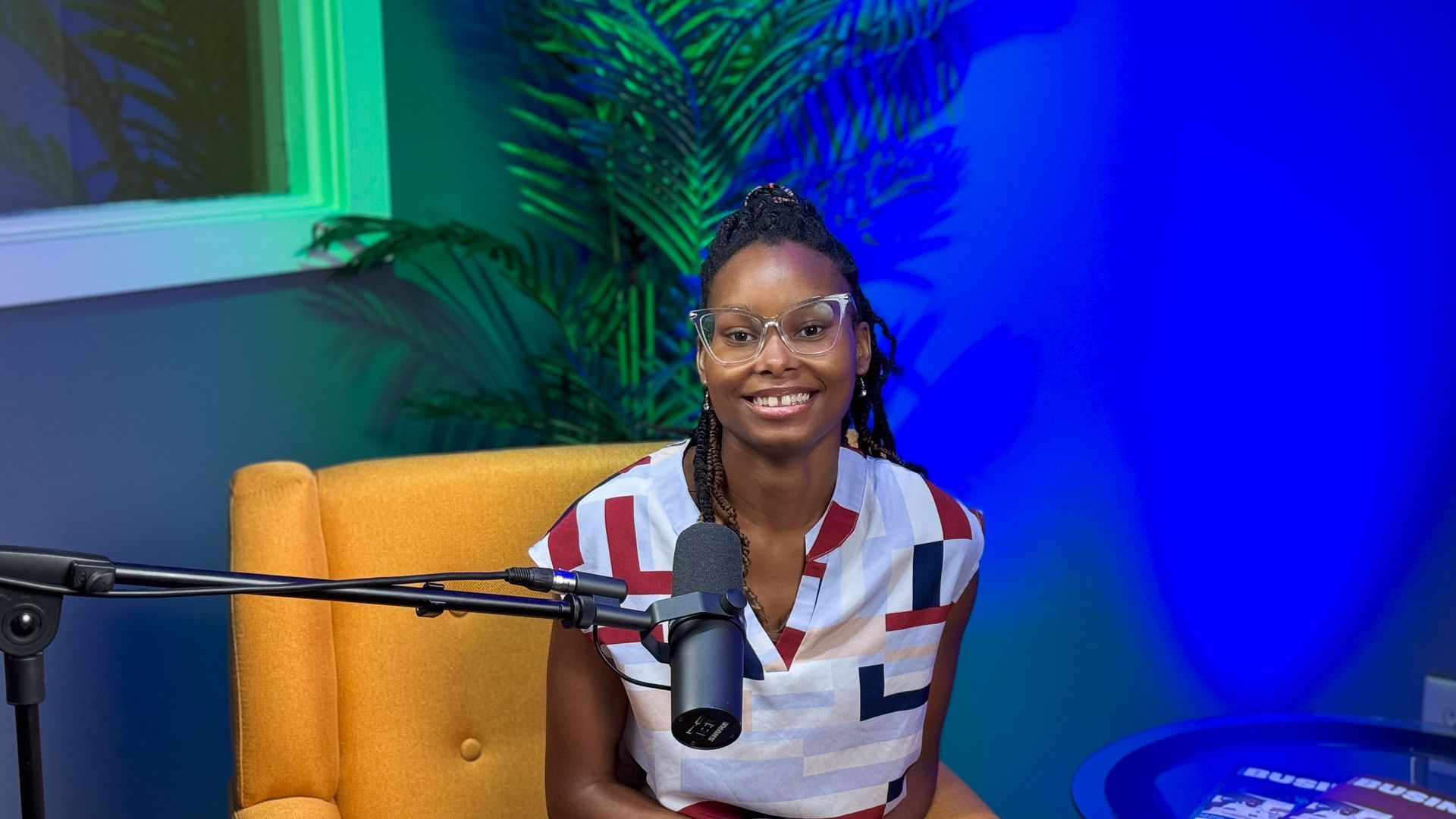 A woman is sitting in a chair in front of a microphone.