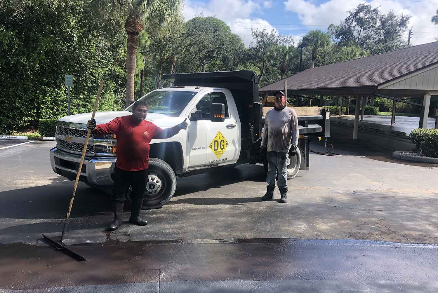Two men are standing next to a truck in a parking lot.