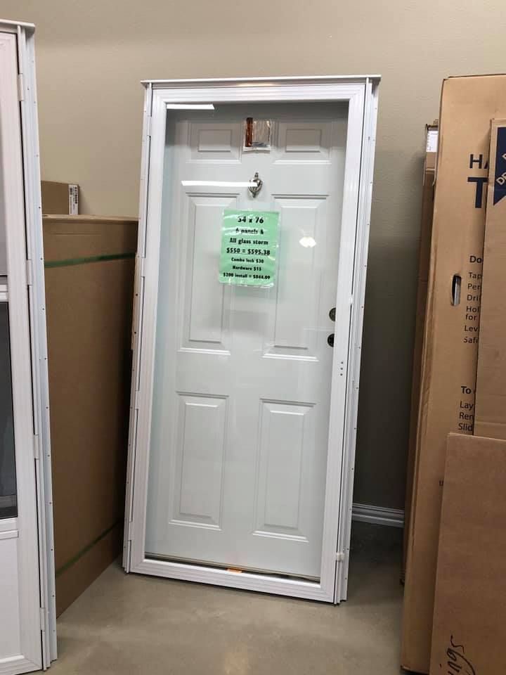 Assortment of window frames in various styles and colors displayed in a warehouse setting.