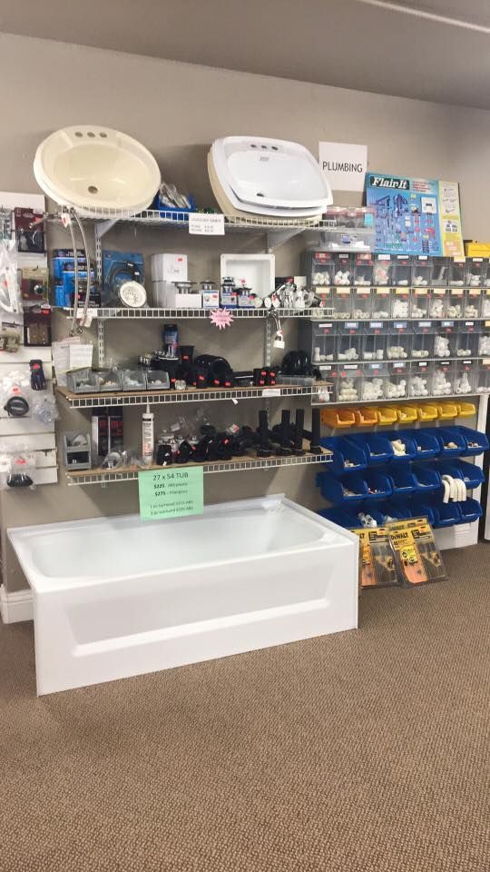 Display of chrome and white kitchen faucets in a hardware store.
