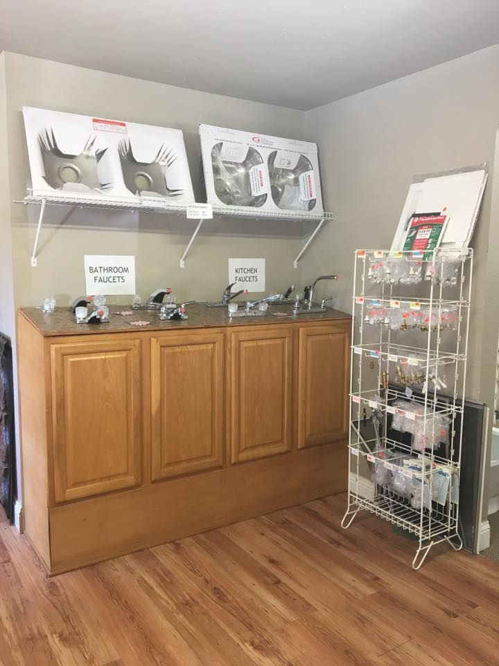 Bathroom accessories on shelves, including towels, toiletries, mirrors, and chrome fixtures against a gray wall.