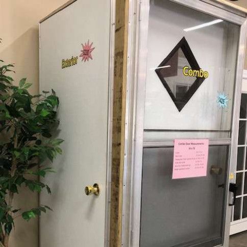 Two doors side-by-side: a white exterior door with a pink sticker and a glass combo door with a price tag.